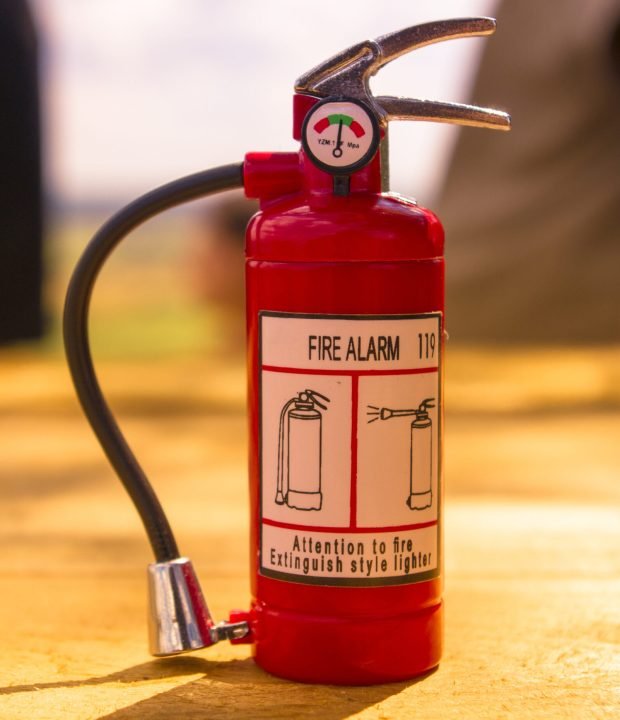 red-fire-extinguisher-on-a-wooden-table-concept-2026-01-09-14-16-08-utc